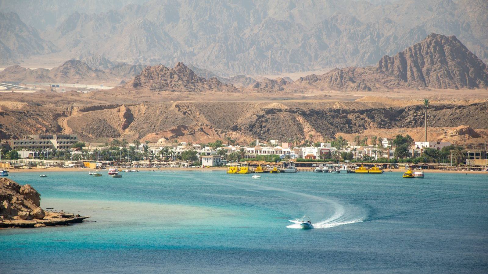 خليج في شرم الشيخ وفنادق على شاطئه، وخلفه جبال جنوب سيناء